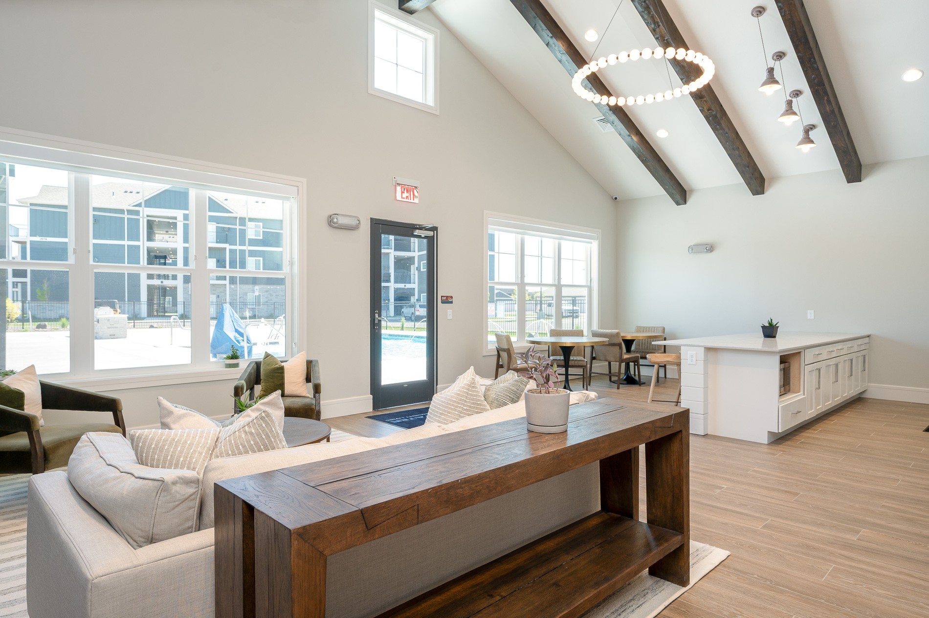 A modern resident clubhouse with a wooden coffee table and a large window.